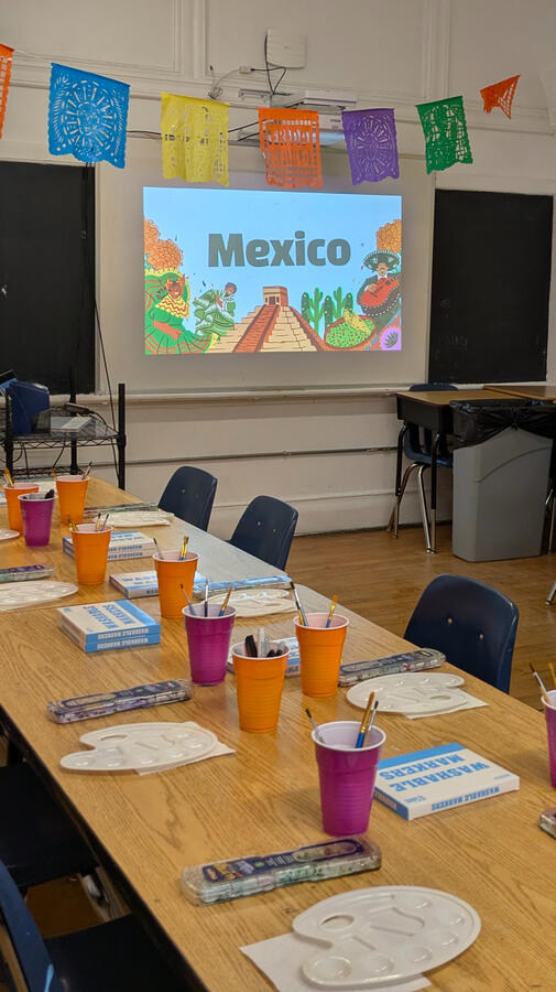 Workshop classroom setup with watercolor supplies and Mexico presentation