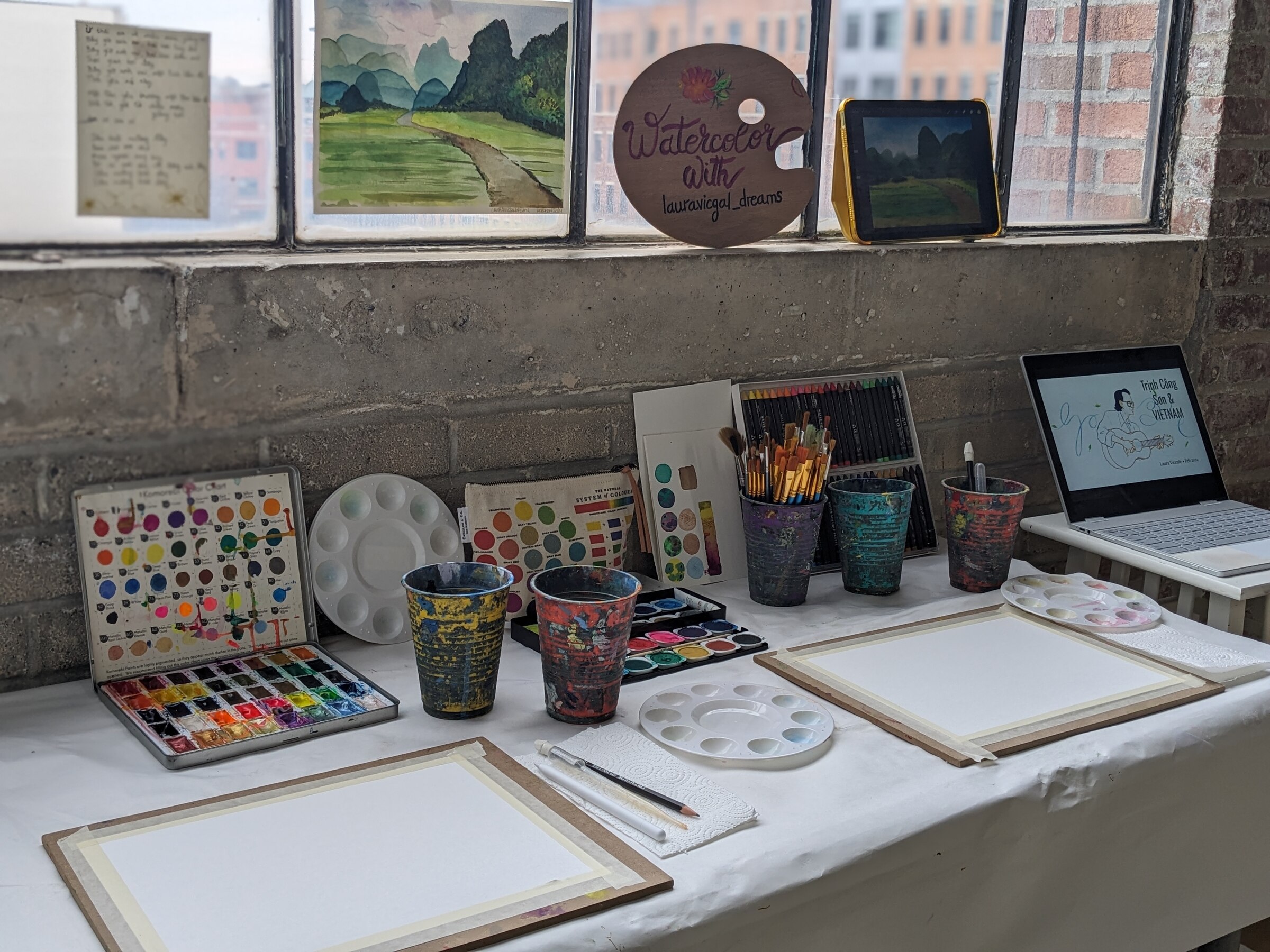 Watercolor workshop materials arranged on a studio table